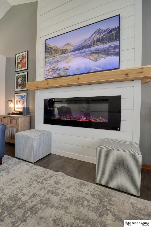 living room with a fireplace, wood finished floors, vaulted ceiling, and baseboards