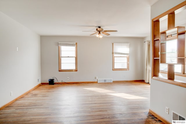 spare room with a ceiling fan, wood finished floors, and baseboards