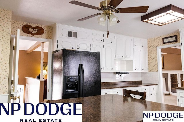 kitchen with black fridge with ice dispenser, wallpapered walls, dark countertops, and white cabinetry