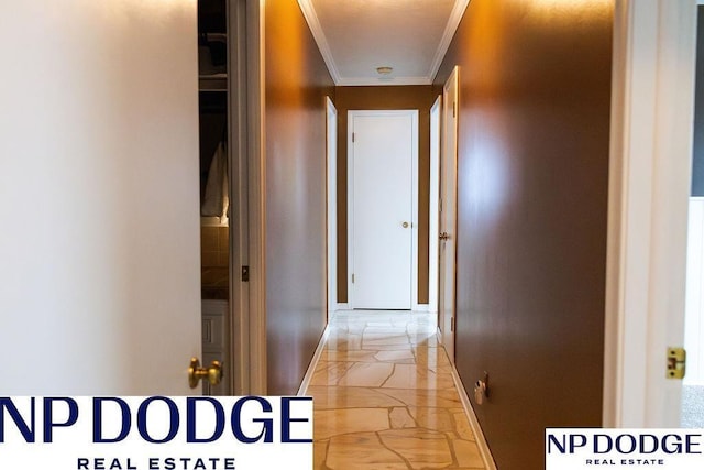 hallway featuring ornamental molding, light marble finish floors, and baseboards