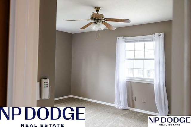 carpeted spare room featuring ceiling fan and baseboards