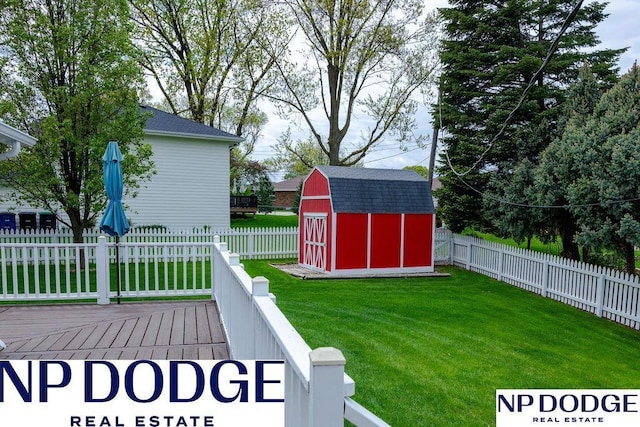 view of yard featuring a storage unit, a deck, and an outdoor structure