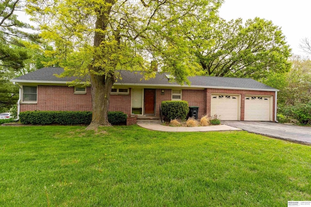 single story home featuring an attached garage, driveway, a front lawn, and brick siding