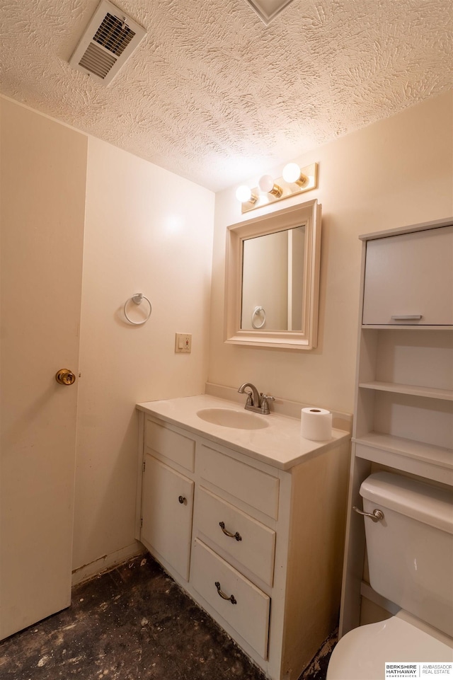bathroom featuring vanity, toilet, and a textured ceiling