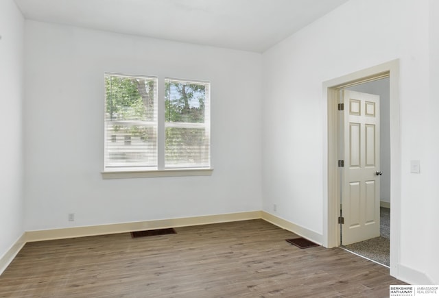 spare room featuring wood finished floors and baseboards