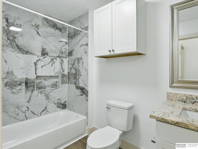 bathroom with toilet, vanity, bathtub / shower combination, and baseboards