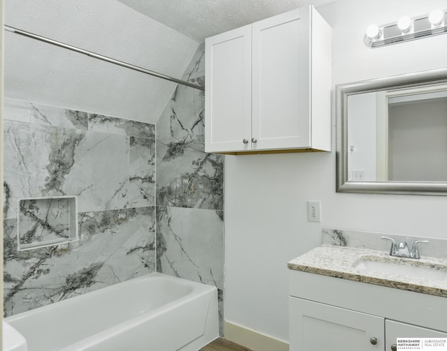 bathroom featuring vanity, shower / bathtub combination, vaulted ceiling, and a textured ceiling