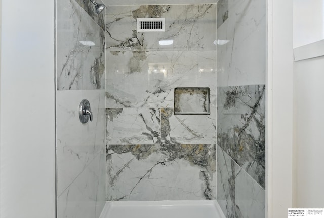 bathroom with a marble finish shower