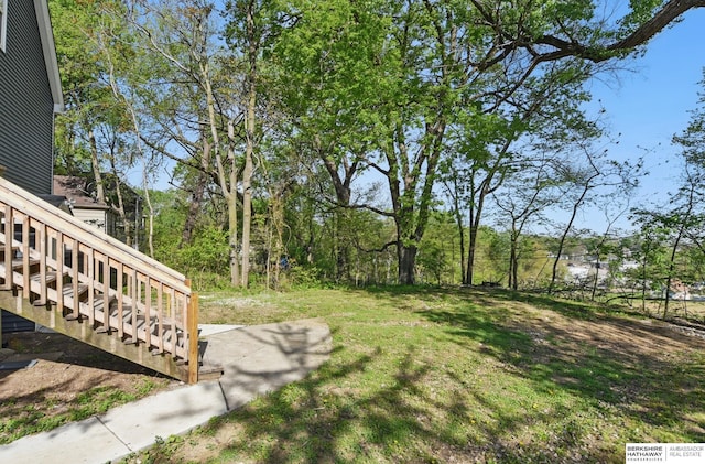 view of green lawn featuring stairway