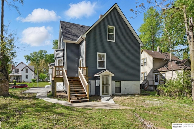 back of house featuring a yard, a shingled roof, stairway, and a deck