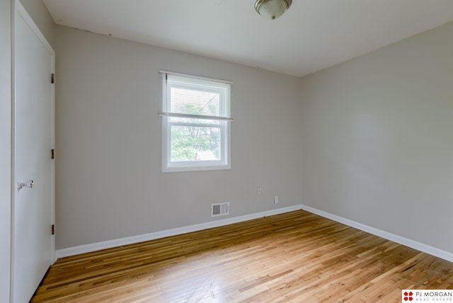unfurnished room with hardwood / wood-style flooring and baseboards