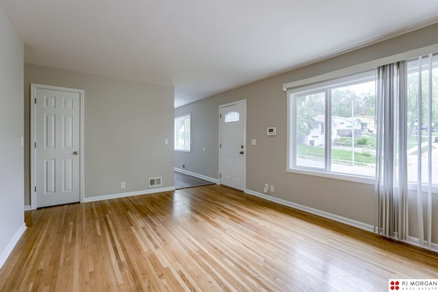 unfurnished living room with light wood finished floors and baseboards