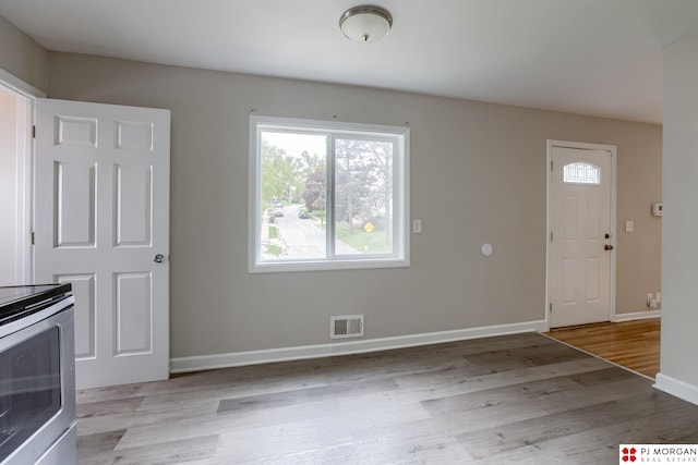 unfurnished living room with baseboards and wood finished floors