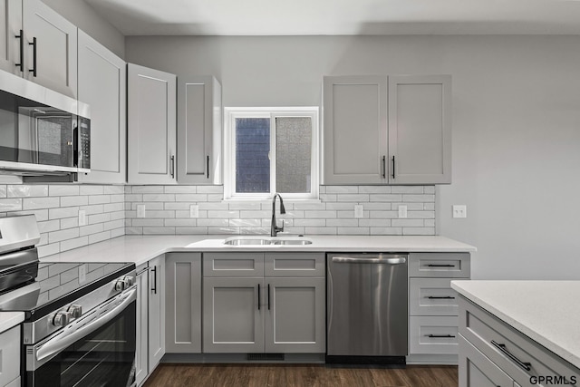 235 N 105th St, Lincoln, NE 68527 - kitchen with appliances with stainless steel finishes, a sink, backsplash, and dark wood-type flooring