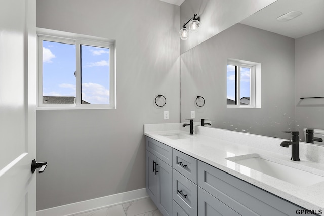 235 N 105th St, Lincoln, NE 68527 - bathroom featuring baseboards, marble finish floors, healthy amount of natural light, and double vanity