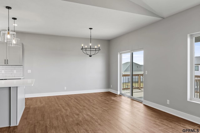 235 N 105th St, Lincoln, NE 68527 - unfurnished dining area with wood finished floors, baseboards, and a chandelier