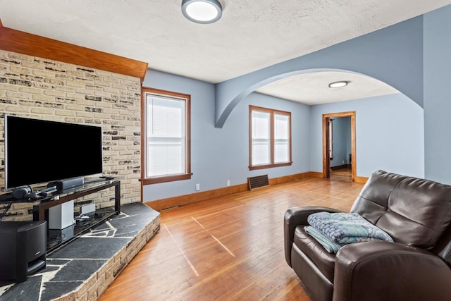 929 Main St, Seward, NE 68434 - living room featuring arched walkways, hardwood / wood-style floors, baseboards, and a textured ceiling