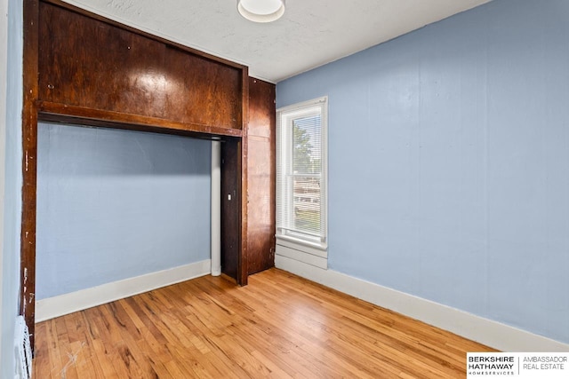 929 Main St, Seward, NE 68434 - unfurnished bedroom with light wood-style flooring, baseboard heating, baseboards, and a closet