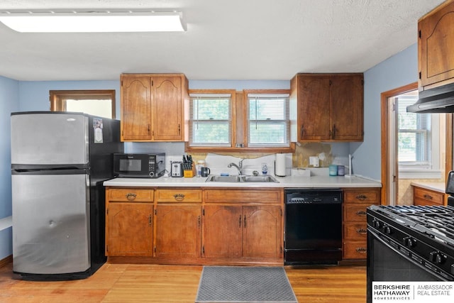 929 Main St, Seward, NE 68434 - kitchen with black appliances, a sink, light wood-style floors, and healthy amount of natural light