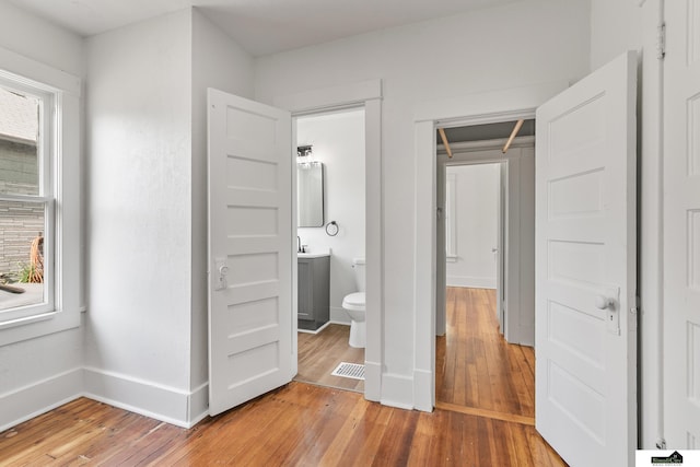 2139 S 8th St, Lincoln, NE 68502 - unfurnished bedroom featuring light wood-type flooring, multiple windows, and baseboards