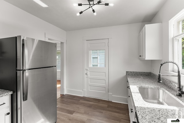 2139 S 8th St, Lincoln, NE 68502 - kitchen featuring freestanding refrigerator, a sink, dark wood finished floors, white cabinetry, and a chandelier