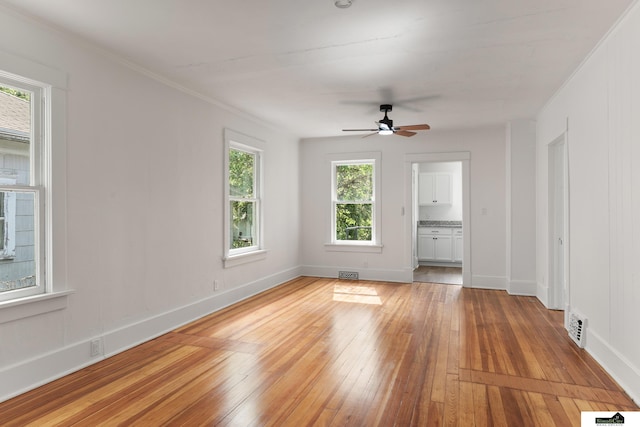 2139 S 8th St, Lincoln, NE 68502 - empty room with light wood finished floors, a ceiling fan, ornamental molding, and baseboards