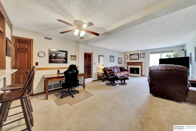carpeted office space with ceiling fan, a textured ceiling, a fireplace, and baseboards