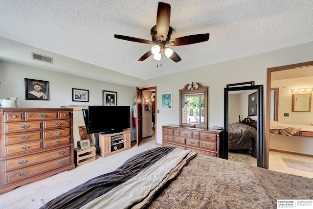 bedroom featuring a textured ceiling, ceiling fan, ensuite bath, and light tile patterned flooring