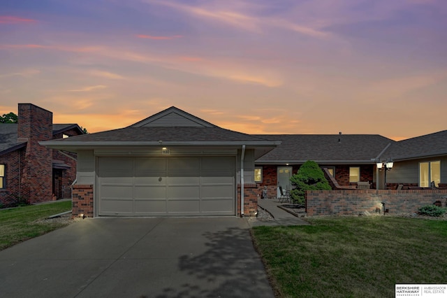 view of front of house featuring concrete driveway, brick siding, an attached garage, and a front yard