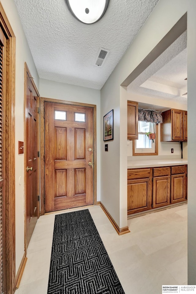 doorway featuring a textured ceiling and baseboards