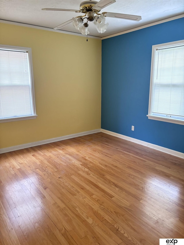 empty room featuring ceiling fan, light wood-style floors, ornamental molding, and baseboards