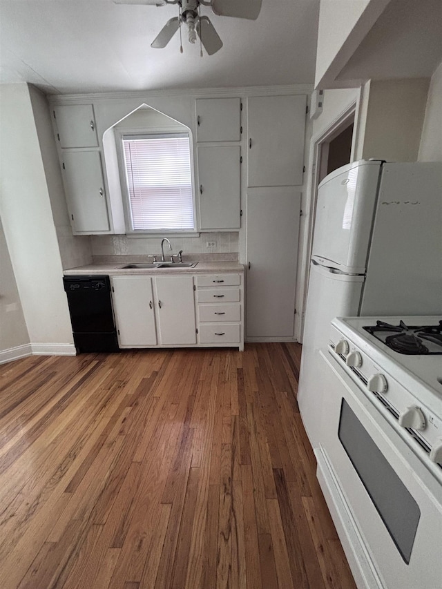 kitchen featuring white appliances, a sink, a ceiling fan, hardwood / wood-style flooring, and light countertops