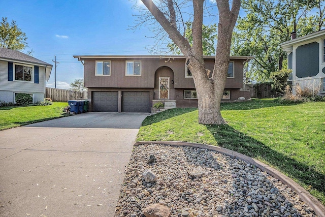raised ranch with concrete driveway, an attached garage, and stucco siding