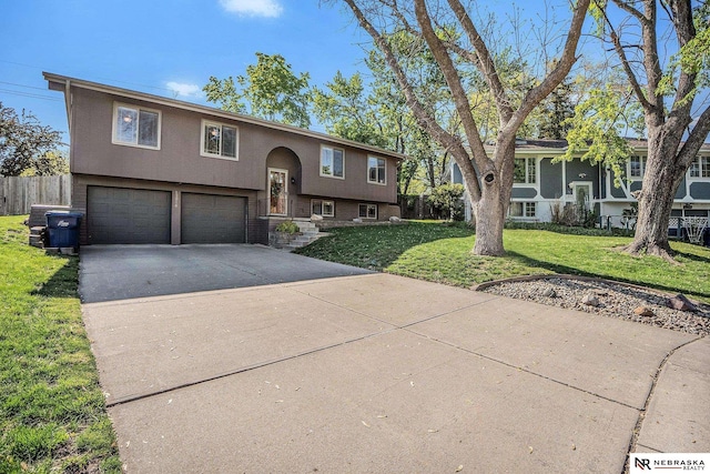 split foyer home featuring concrete driveway, stucco siding, and a garage