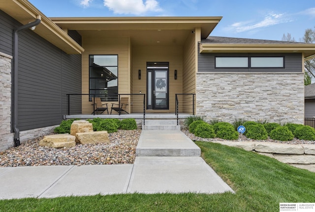 doorway to property featuring a porch and stone siding