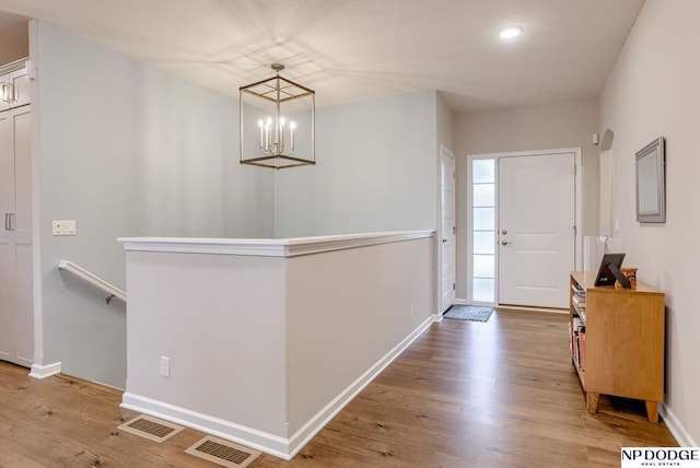 entryway with wood finished floors, a chandelier, baseboards, and recessed lighting