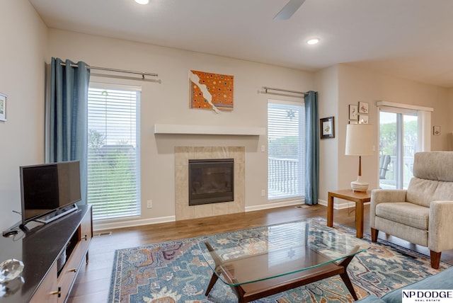 living area with wood finished floors, a fireplace, plenty of natural light, and recessed lighting