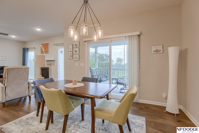 dining area featuring healthy amount of natural light, baseboards, wood finished floors, a tile fireplace, and recessed lighting