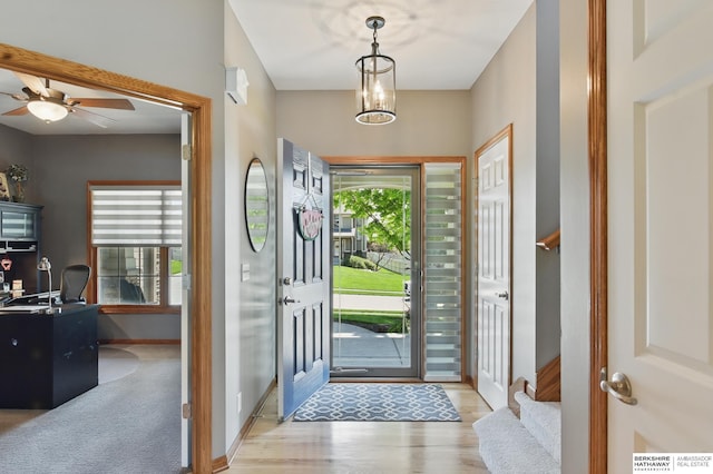 foyer entrance with baseboards, a ceiling fan, and wood finished floors