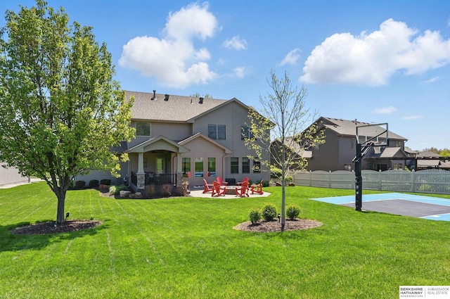 back of property with basketball hoop and a patio