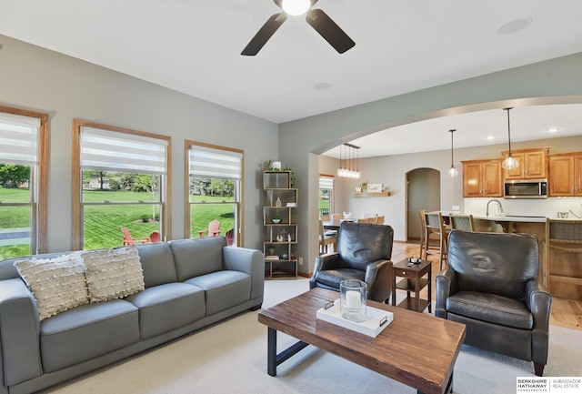 living room featuring arched walkways, ceiling fan, light colored carpet, and recessed lighting