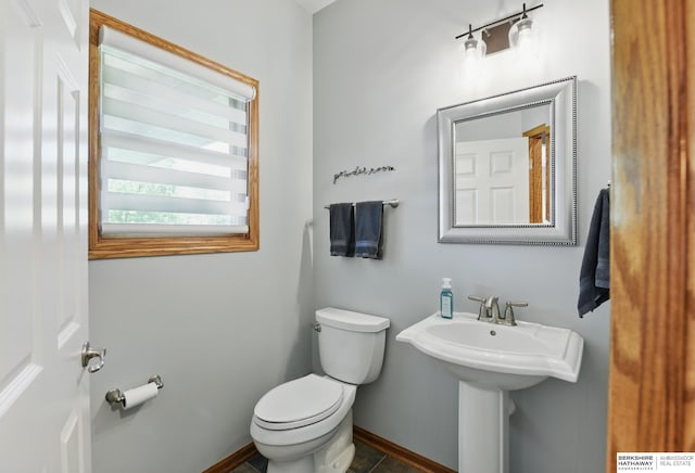 bathroom with toilet and baseboards