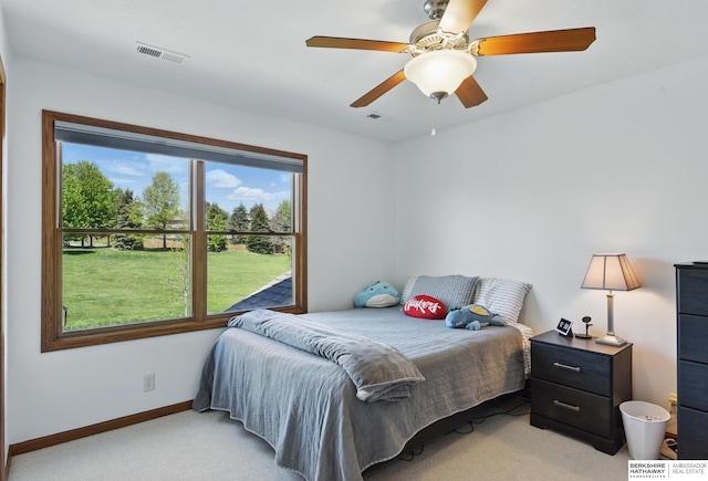 bedroom with light carpet, multiple windows, baseboards, and a ceiling fan