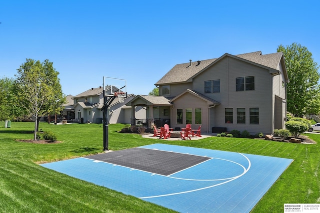 view of sport court featuring basketball hoop and a lawn