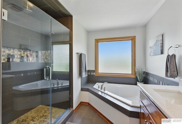 full bathroom with a garden tub, a shower stall, and vanity