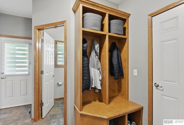 mudroom featuring stone finish flooring and baseboards