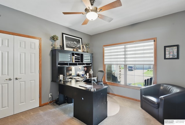 office space with light colored carpet, ceiling fan, and baseboards