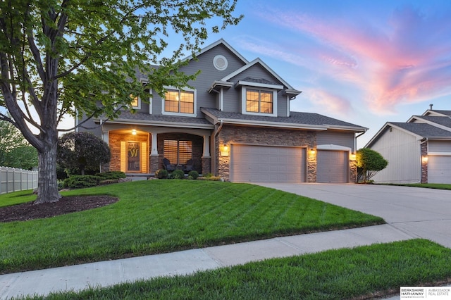 view of front of home with driveway, stone siding, and an attached garage