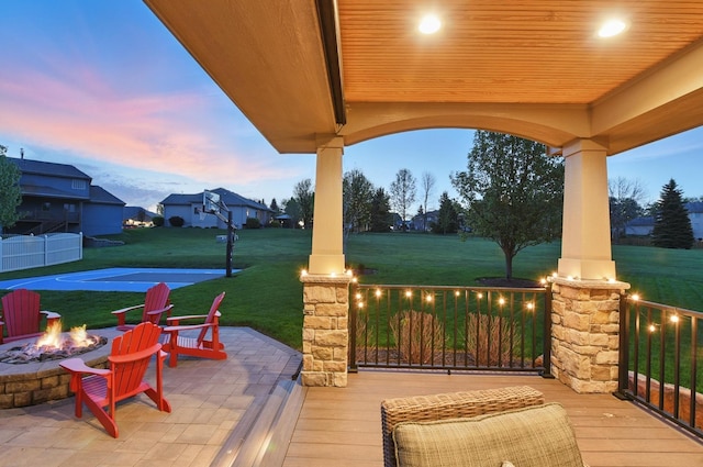 deck with an outdoor fire pit and a yard
