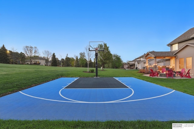 view of basketball court featuring basketball hoop and a yard